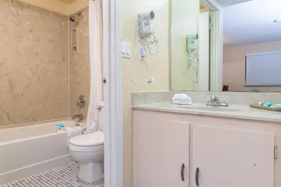 a bathroom with a toilet and a phone on the wall at Sevilla Inn Kissimmee- Near Disney in Kissimmee