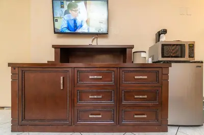 a wooden dresser with a television on a wall at Sevilla Inn Kissimmee- Near Disney in Kissimmee