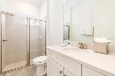 a white bathroom with a toilet and a shower at Relaxing Cottage Near Disney With Margaritaville Resort & Island H20 Waterpark Access - 2964Sr in Orlando