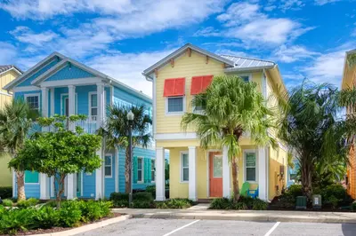 a row of colorful houses with palm trees at Sunny Yellow Cottage Near Disney With Margaritaville Resort Access & Island H20 Waterpark - 3075Kl in Orlando
