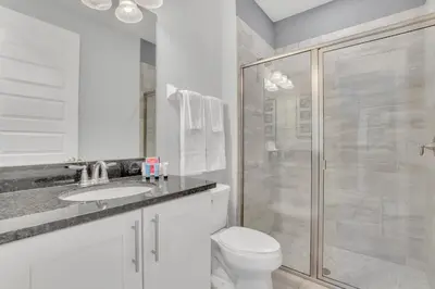 a white bathroom with a toilet and a shower at 650 Lasso Drive in Orlando