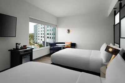 a hotel room with two beds and a window at Aloft Orlando International Drive by Marriott in Orlando
