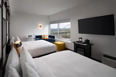 a hotel room with two beds and a flat screen tv at Aloft Orlando International Drive by Marriott in Orlando