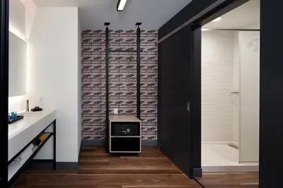 a bathroom with a brick wall and a black door at Aloft Orlando International Drive by Marriott in Orlando