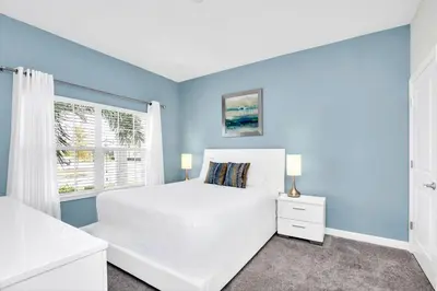 a bedroom with a white bed and a window at Family Resort - 4BR Home Near Disney - Private Pool, BBQ! in Kissimmee