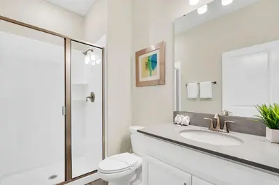 a white bathroom with a toilet and a sink at Family Resort - 4BR Home Near Disney - Private Pool, BBQ! in Kissimmee