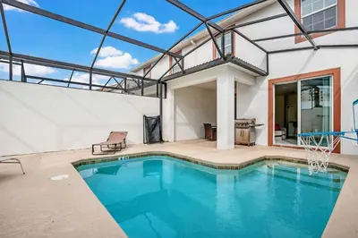 a house with a pool and a basketball hoop at Family Resort - 4BR Home Near Disney - Private Pool, BBQ! in Kissimmee