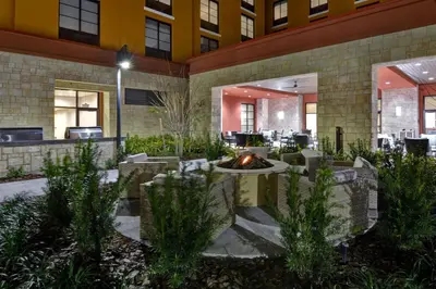 a courtyard with a fire pit in a building at Home2 Suites By Hilton Orlando Flamingo Crossings, FL in Orlando