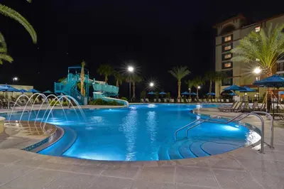 a pool at a resort at night at Home2 Suites By Hilton Orlando Flamingo Crossings, FL in Orlando