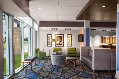 a lobby with chairs and a couch and tables at Holiday Inn Express & Suites Sanford - Lake Mary by IHG in Sanford