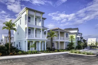 a white house with palm trees in a parking lot at Vivid Cottage Near Disney With Margaritaville Resort & Island H2O Access - 8024Ls in Orlando