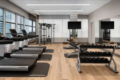 a gym with rows of treadms and pilates equipment at AC Hotel by Marriott Orlando Downtown in Orlando