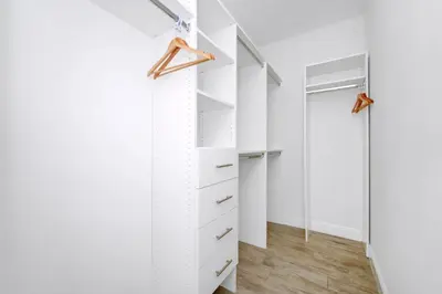 a walk in closet with white walls and wood floors at Dreamy Cottage Near Disney With Margaritaville Resort & Island H2O Access - 8069Kd in Orlando