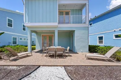a patio with a table and chairs in front of a building at Dreamy Cottage Near Disney With Margaritaville Resort & Island H2O Access - 8069Kd in Orlando