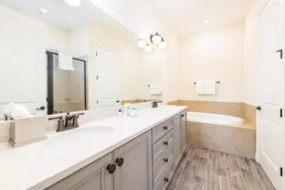 a white bathroom with two sinks and a tub at Paradise Cottage Near Disney With Margaritaville Resort & Island H20 Access - 8137Su in Orlando