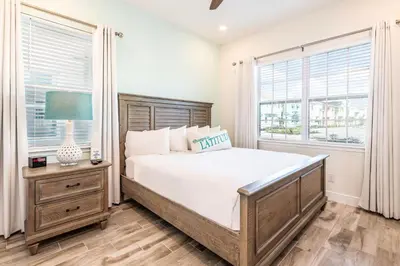a bedroom with a large bed and two windows at Beautiful Cottage With Private Pool Near Disney With Margaritaville Resort & Island H20 Access - 8153Su in Orlando