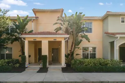 a house with palm trees in front of it at Townhome w pool near Disney & Orlando Attractions in Kissimmee