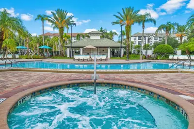 a pool at a resort with palm trees at Epic Universe Beautiful Modern Condo - Vista Cay Resort - 2007 in Orlando