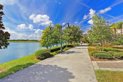 a sidewalk next to a lake with a street light at Epic Universe Beautiful Modern Condo - Vista Cay Resort - 2007 in Orlando