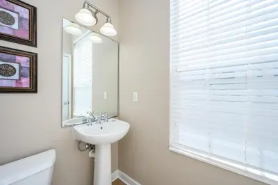 a white bathroom with a sink and a mirror at Gorgeous Vista Cay Town Home, Vista Cay - 4002 in Orlando