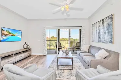 a living room with a couch and a tv at Stunning 3BR Near Disney - Pool and Hot Tub! in Orlando