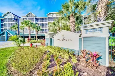 a villa with palm trees and a building at Stunning 3BR Near Disney - Pool and Hot Tub! in Orlando