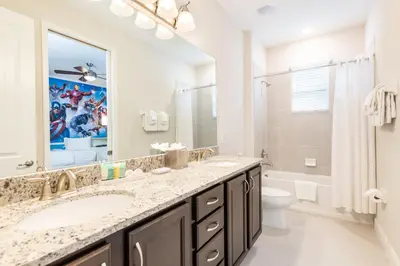 a bathroom with a sink and a toilet and a mirror at Elegant Home Near Disney With Private Pool, Foosball Table, Themed Rooms And Waterpark & Resort Access At Encore Resorts Reunion - 365Sf in Kissimmee