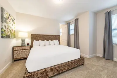 a bedroom with a large white bed and windows at Spacious Home With Game Room, Private Pool And Waterpark & Resort Access Near Disney At Encore Resorts Reunion - 241Sf in Kissimmee