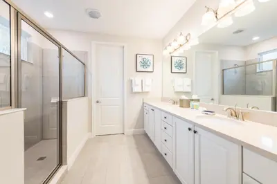 a white bathroom with two sinks and a shower at Spacious Home With Game Room, Private Pool And Waterpark & Resort Access Near Disney At Encore Resorts Reunion - 241Sf in Kissimmee