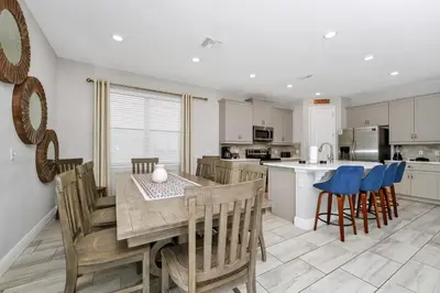 a kitchen and dining room with a table and chairs at Grand Home Near Disney With Private Pool, Air Hockey Table And Waterpark & Resort Access At Encore Resorts Reunion - 401Sf in Kissimmee