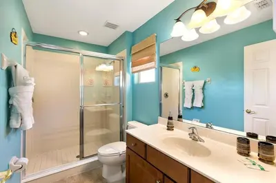 a bathroom with a shower and a toilet and a sink at Lakeview 6-Bedroom Retreat with Game Room, Private Pool, Spa & Resort Amenities - Ideal for Families & Groups in Kissimmee