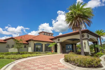 a house with a palm tree in the driveway at Lakeview 6-Bedroom Retreat with Game Room, Private Pool, Spa & Resort Amenities - Ideal for Families & Groups in Kissimmee