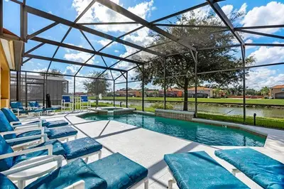 a swimming pool with lounge chairs and a swimming pool at Lakeview 6-Bedroom Retreat with Game Room, Private Pool, Spa & Resort Amenities - Ideal for Families & Groups in Kissimmee