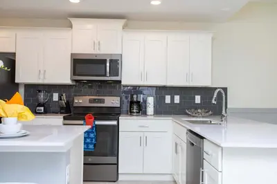 a kitchen with white cabinets and black appliances at Luxurious 2 Bd Close to Disney @ Storey Lake 204P in Kissimmee