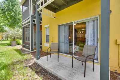 a yellow house with two chairs on a porch at Near Disney and Epic Universe Home with Resort Perks in Kissimmee
