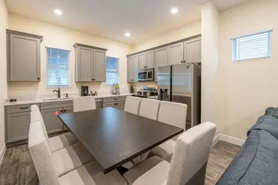 a kitchen and dining room with a table and chairs at Cocktails & Dreams Cottage With Private Pool Near Disney With Margaritaville Resort & Island H2O Access - 8005St in Orlando