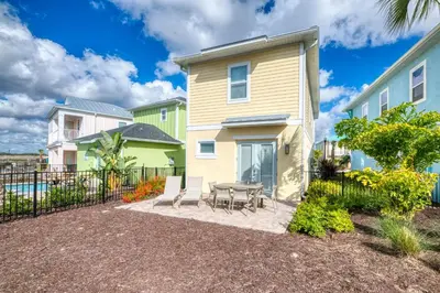 a patio with a table and chairs in front of a house at Brilliant Cottage Near Disney With Margaritaville Resort & Island H2O Access - 8090Kd in Orlando