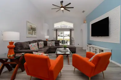 a living room with a couch and chairs and a tv at Making Dreams 4BR Family Villa with Pool and Game Room Near Disney Parks in Kissimmee