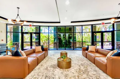 a living room with leather furniture and large windows at Spacious 3BR Near Disney - Pool in Orlando
