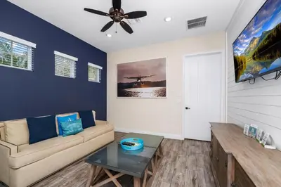 a living room with a couch and a ceiling fan at Pineapple Dream Cottage With Private Hot Tub Near Disney With Margaritaville Resort & Island H2O Access - 8000Sb in Orlando