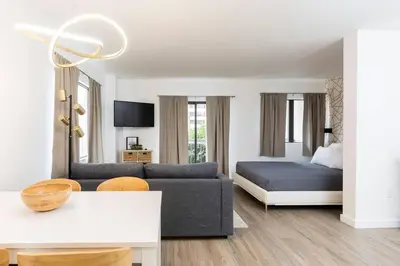 a living room with a couch and a bed at Modern Studio on I-Drive: parking + pool included in Orlando