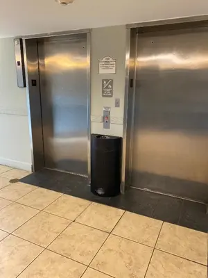 a metal elevator with a trash can in a room at Modern Studio on I-Drive: parking + pool included in Orlando