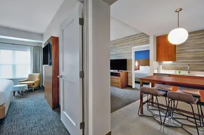 a hotel room with a kitchen and a dining room at Residence Inn by Marriott Orlando at FLAMINGO CROSSINGS Town Center in Orlando