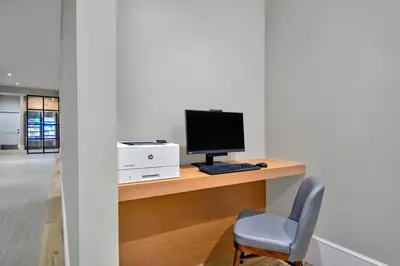 a computer sitting on a desk with a chair at Residence Inn by Marriott Orlando at FLAMINGO CROSSINGS Town Center in Orlando