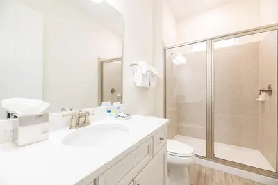 a white bathroom with a toilet and a shower at Vivid Cottage Near Disney With Margaritaville Resort & Island H2O Access - 8020Ff in Orlando