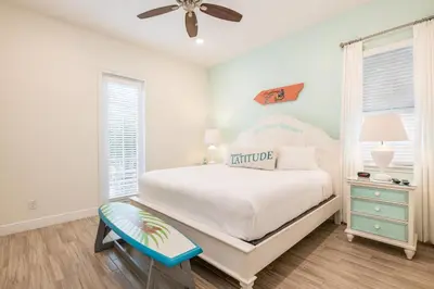 a bedroom with a white bed and a blue stool at Vivid Cottage Near Disney With Margaritaville Resort & Island H2O Access - 8020Ff in Orlando