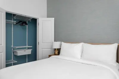 a bedroom with a white bed and a blue wall at TownePlace Suites By Marriott Orlando Southwest Near Universal in Orlando