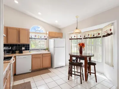 a kitchen with a table and a refrigerator at bsv_villa1607 in Orlando