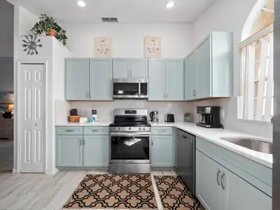 a kitchen with blue cabinets and a sink and a stove at bsv_villa1607 in Orlando