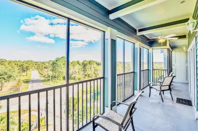 a balcony with two chairs and a view of the water at Luxury 3BR Near Disney - Pool in Orlando